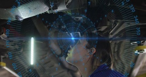Female mechanic diagnosing vehicle undercarriage with ar hud and led inspection light