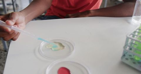 Student experimenting in science lab with blue-green solution