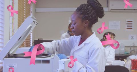 Scientist conducting research while breast cancer ribbons illuminate scene
