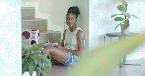 Woman Writing Intently with Notebook in Modern Home Interior