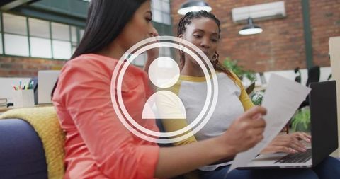 Two women collaborating on project in modern coworking space