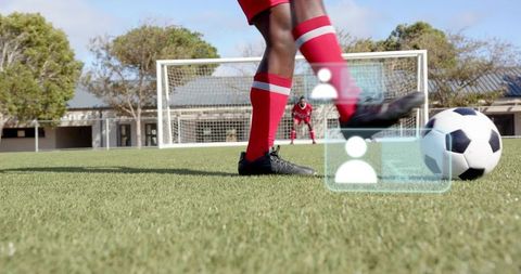 Kicking Soccer Player Striking Ball Toward Goal with AR Overlays on School Pitch