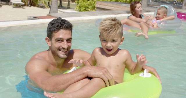 Family Enjoying Vacation Swimming in Pool with Inflatable Rings on Sunny Day - Download Free Stock Images Pikwizard.com