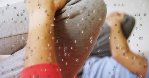 Trainer supporting client holding bent knee stretch with digital binary overlay