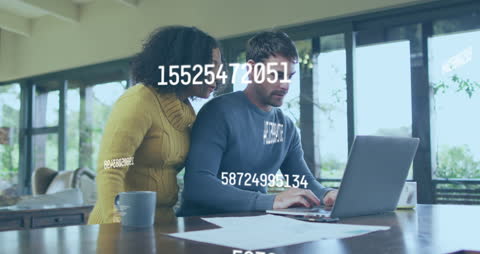 Diverse Couple Analyzing Data on Laptop with Digital Overlay