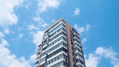 Tall modern residential condo building with blue sky
