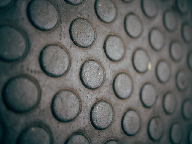 This image showcases a close-up view of a textured surface with circular patterns and a 3D effect on a grey background. Great for use in graphic design projects, web design backgrounds, architectural inspirations, material studies, or as a unique texture in creative artworks.