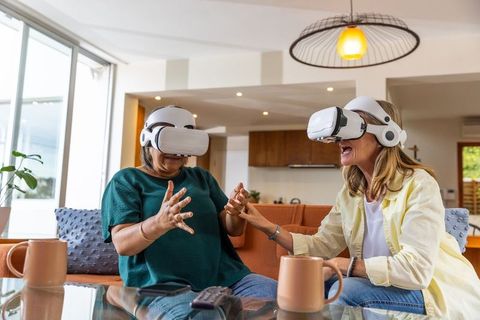 Senior women enjoying virtual reality in bright cozy living room