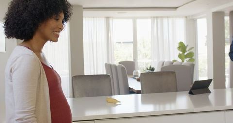 Pregnant Woman Counting Notes On Dining Table