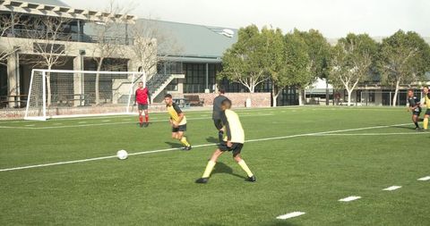 Youth soccer players practicing on field in sunny weather