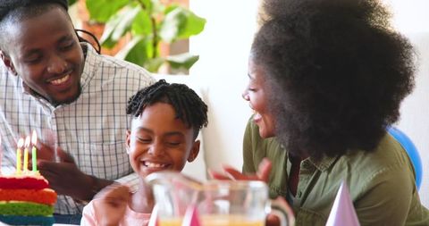 Family Celebrating Birthday with Smiles and Cake at Home