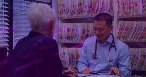 Doctor reviewing patient files during consultation in modern office