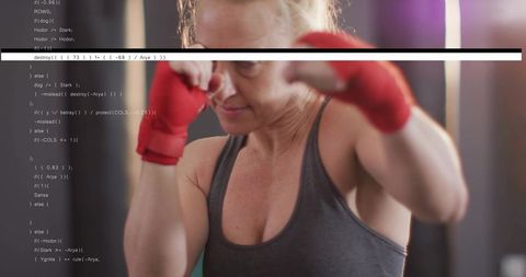 Female boxer training and throwing punch with red hand wraps and programming code overlay