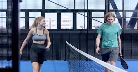 Friends Walking on Paddle Court with Rackets Displaying Sportsmanship