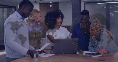Multicultural Team Collaborating on Global Strategy with Laptop and Documents