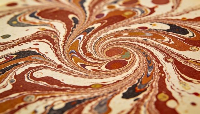 Swirling marbled paper with layered pigments and textured spiral pattern