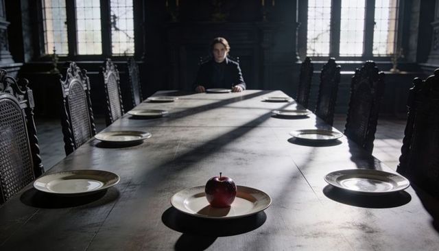 Solitary Figure Sitting at Long Banquet Table with Single Red Apple under Dramatic Sunlight