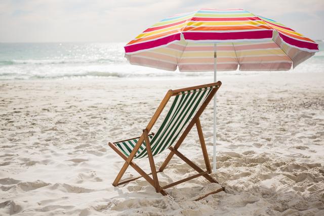 Empty beach chair and parasol at tropical sand beach