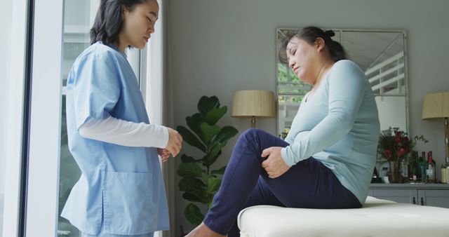Health professional examining woman with knee pain in a clinic. Ideal for medical and healthcare content, patient care illustrations, pain relief resources, physical therapy, and elder care services.