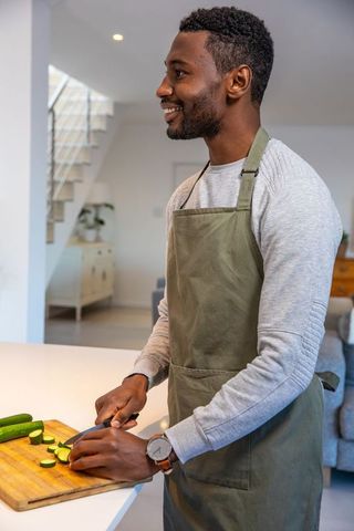 Man Slicing Cucumbers in Modern Kitchen