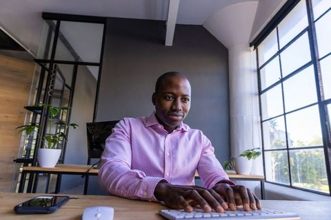 Young Professional Typing on Keyboard in Modern Office