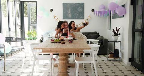 Friends Celebrating Birthday with Selfies in Bright Dining Room