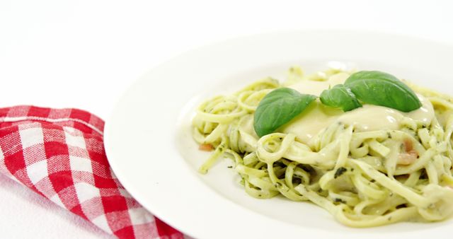 Creamy Basil Pesto Pasta on White Plate with Red Checkered Napkin - Download Free Stock Images Pikwizard.com