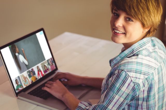 Smiling caucasian girl using laptop for video call, with diverse elementary school pupils on screen. communication technology and online education, digital composite image.