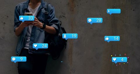 Young man checking phone with floating social media notifications in moody urban alley