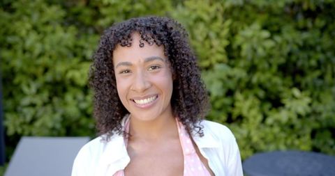 Woman Smiling Outdoors on Sunny Day in Backyard