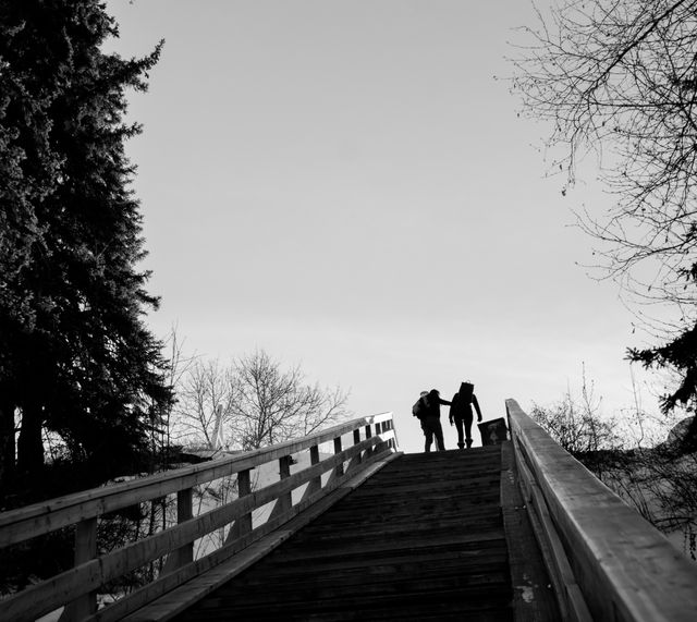 Couple Walking on Wooden Bridge at Sunset - Download Free Stock Photos Pikwizard.com