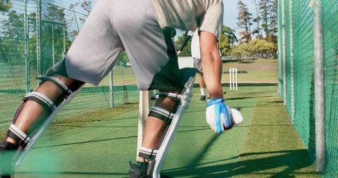 Wicketkeeper diving to stop ball during cricket nets practice team training session