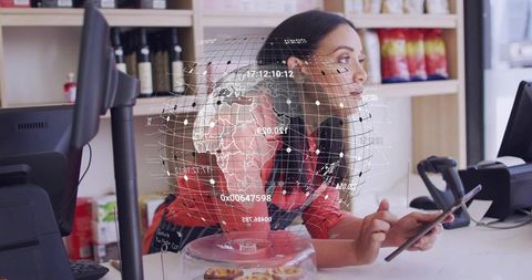 Female barista leaning at counter holding smartphone with digital globe overlay, pastry display and
