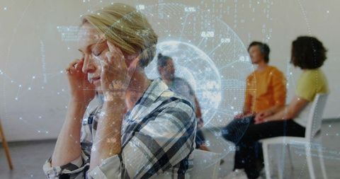 Woman pressing temples during group therapy with augmented reality data visualization for stress