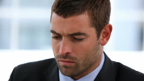 Serious Businessman Overcoming Challenges Happy at Office Desk