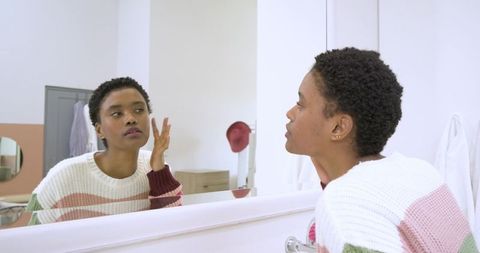 Woman Examining Skincare Routine at Home Bathroom