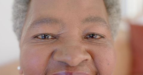 Closeup portrait smiling senior african woman showing warm eyes and pearl earring