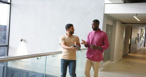 Diverse business colleagues discussing work in modern hallway