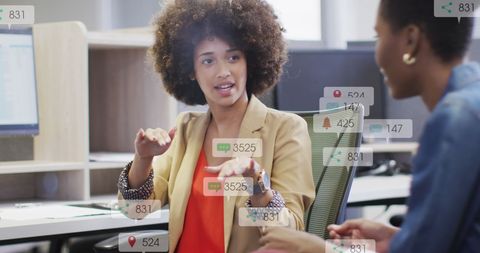 Diverse Businesswomen Strategizing with Social Media Icons Overlay