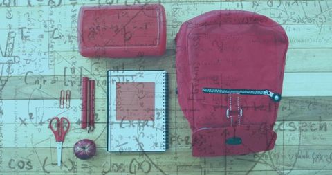 Red backpack with supplies and math overlay on wooden desk