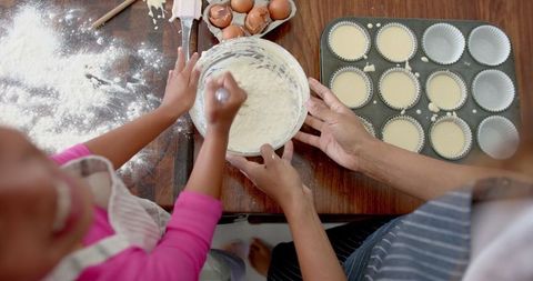Mother and Daughter Baking Cupcakes in Kitchen