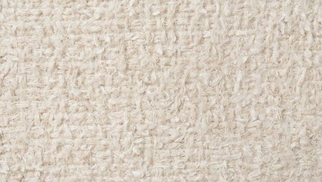 Beige shaggy textile revealing looped weave and fluffy yarn tufts for soft neutral texture