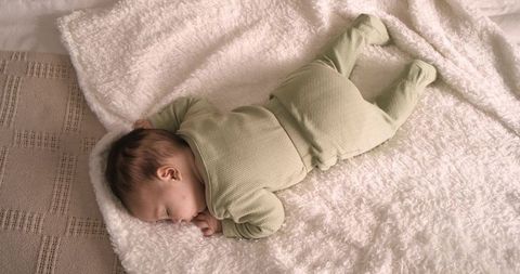 Sleeping Infant Lying on Soft Blanket in Cozy Nursery