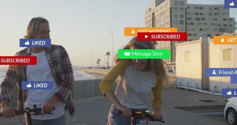Young couple riding e-scooters on seafront at golden hour with social media notifications
