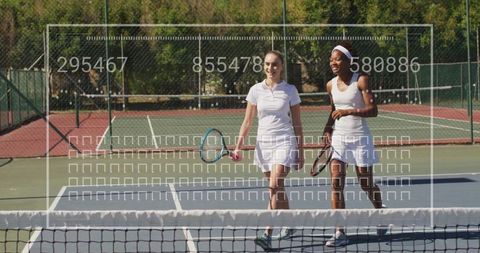 Female sports duo in action on tennis court with rackets