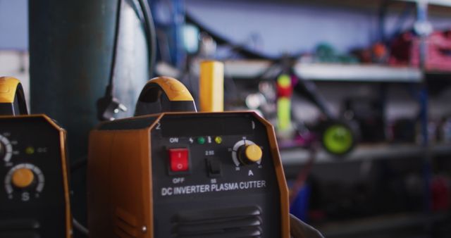Close-up of DC inverter plasma cutter in a workshop, highlighting its control panel. This can be used in content related to industrial tools, workshops, and metalworking projects. Great for illustrating manufacturing, precision engineering, and electrical equipment in use.