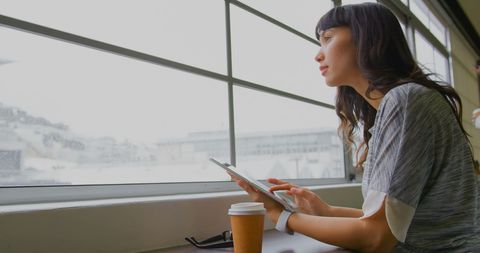 Businesswoman Using Digital Tablet Near Window in Modern Office