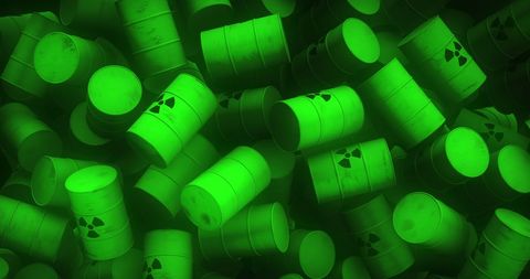 Glowing green toxic barrels with nuclear symbols