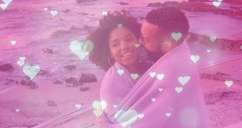Couple Snuggling with Blanket Near Scenic Ocean