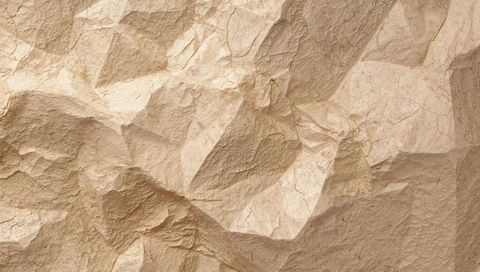 Crumpled beige parchment texture showing sharp creases, folds and fine cracks close-up